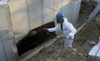Professional waterproofing the exterior walls of the basement in Fort Worth, TX